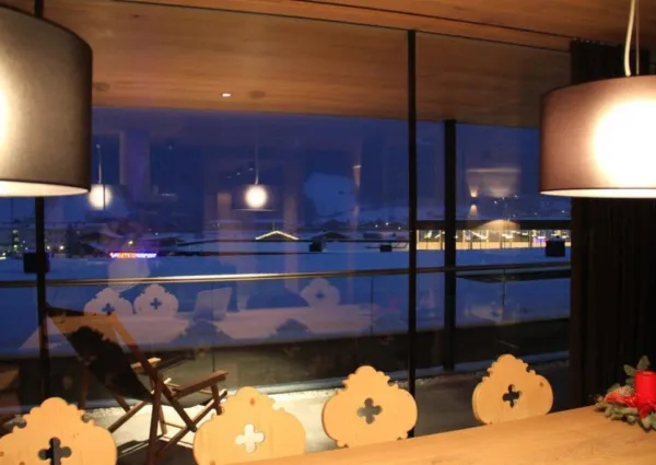 Gemütlicher Essbereich mit Holzstühlen und weitem Blick durch die Glasfront